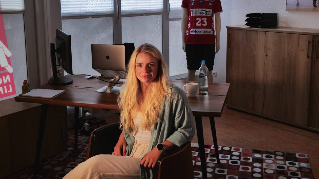 Das Bild zeigt Katharina Schlieke, die neue Verantwortliche für die Öffentlichkeitsarbeit der HSG Nordhorn. Das Foto wurde in ihrem Büro aufgenommen.