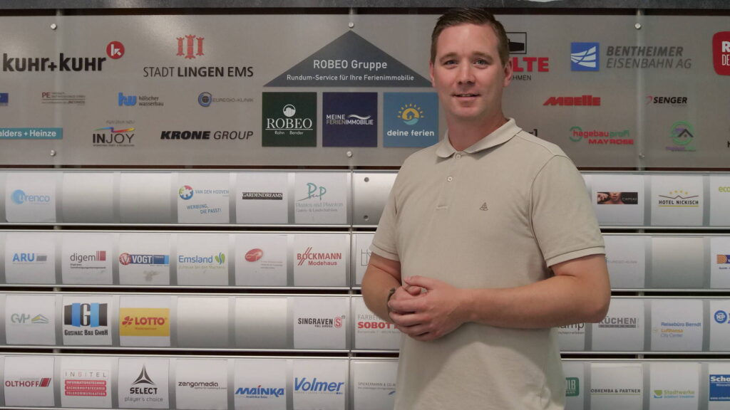 Das Bild zeigt den neuen Account Manager der HSG, Tim Diekmann. Im Hintergrund erkennt man die Sponsoren-Wand von der HSG.