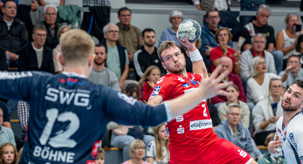 Das Bild zeigt eine Szene aus einem Handballspiel, wo der Spieler mit der Nummer 2 von der HSG Nordhorn-Lingen ein Torwurf durchführt.