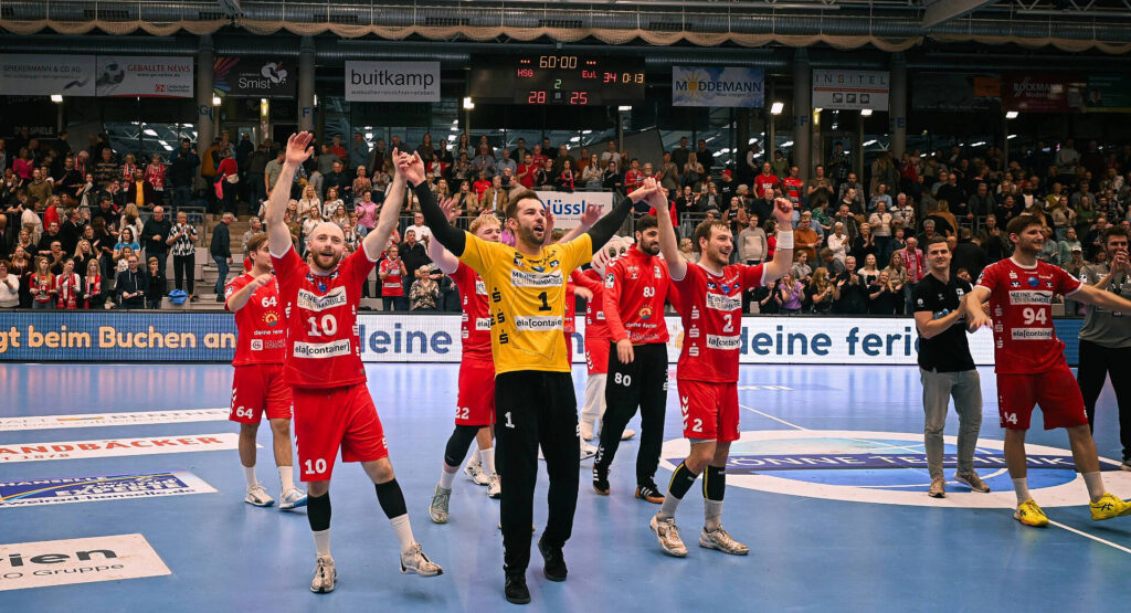 Das Bild zeigt die Mannschaft der HSG Nordhorn-Lingen, wie sie nach Ihrem Sieg jubeln.