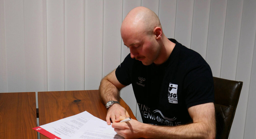 Maximilian Lux bleibt der HSG auch über das Saisonende hinaus erhalten. Das Bild zeigt wie er seinen Vertrag unterschreibt.