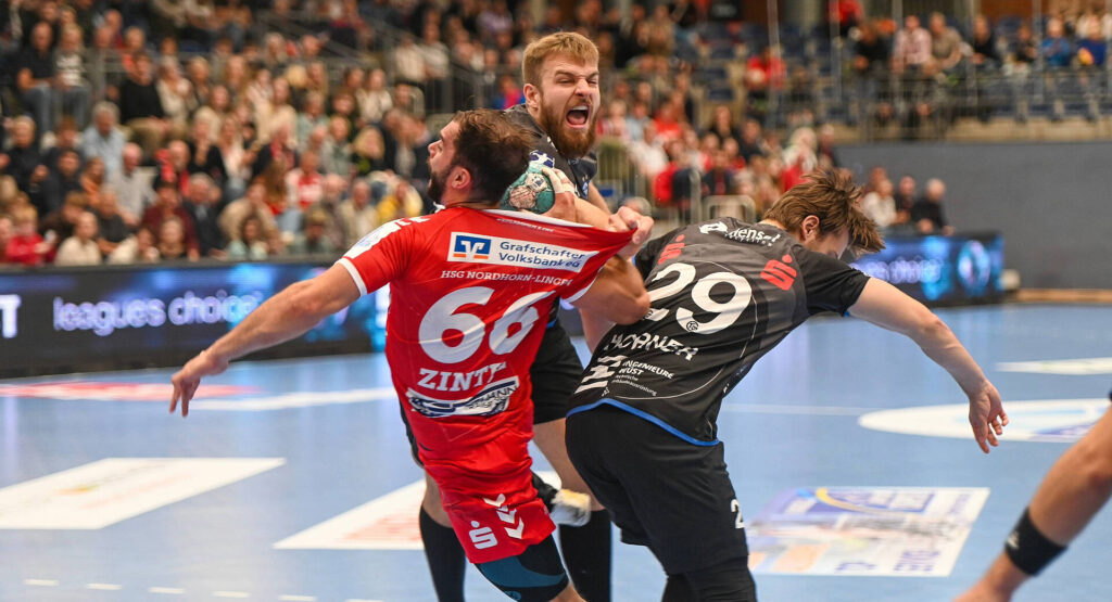 Das Bild zeigt die Nummer 66. Wie er von 2 Gegenspielern geblockt wird.